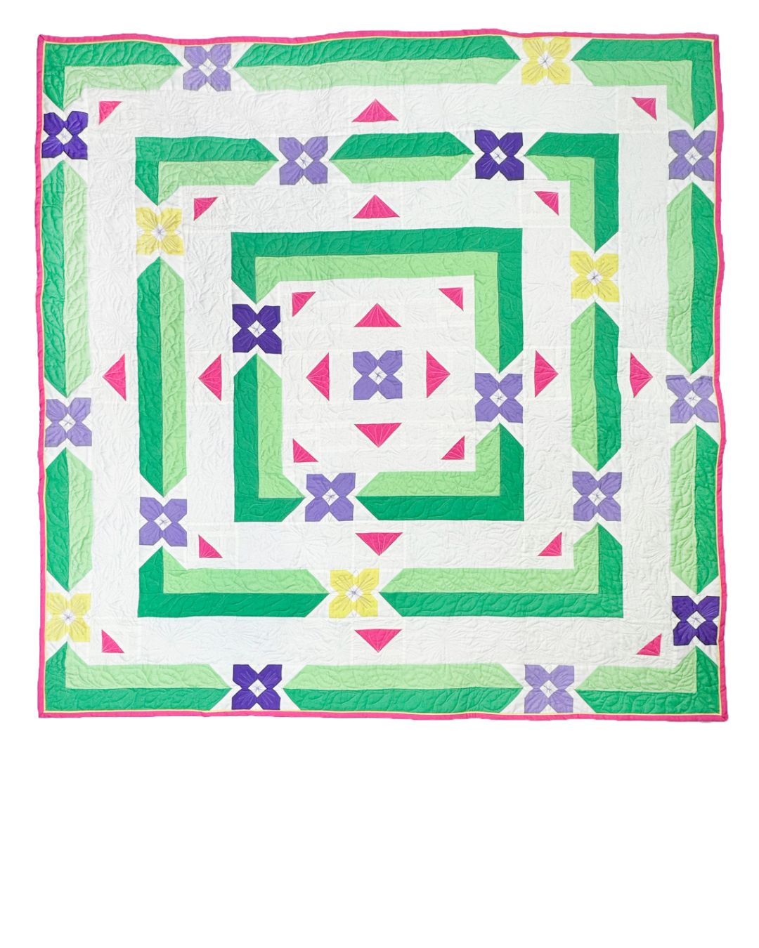 Albion Blooms quilt. A geometric quilt with small flower motifs surrounded by repeating medallion strips and triangles. Made in purple, pink, yellow, and green fabrics on a white background. Displayed flat on a white surface.