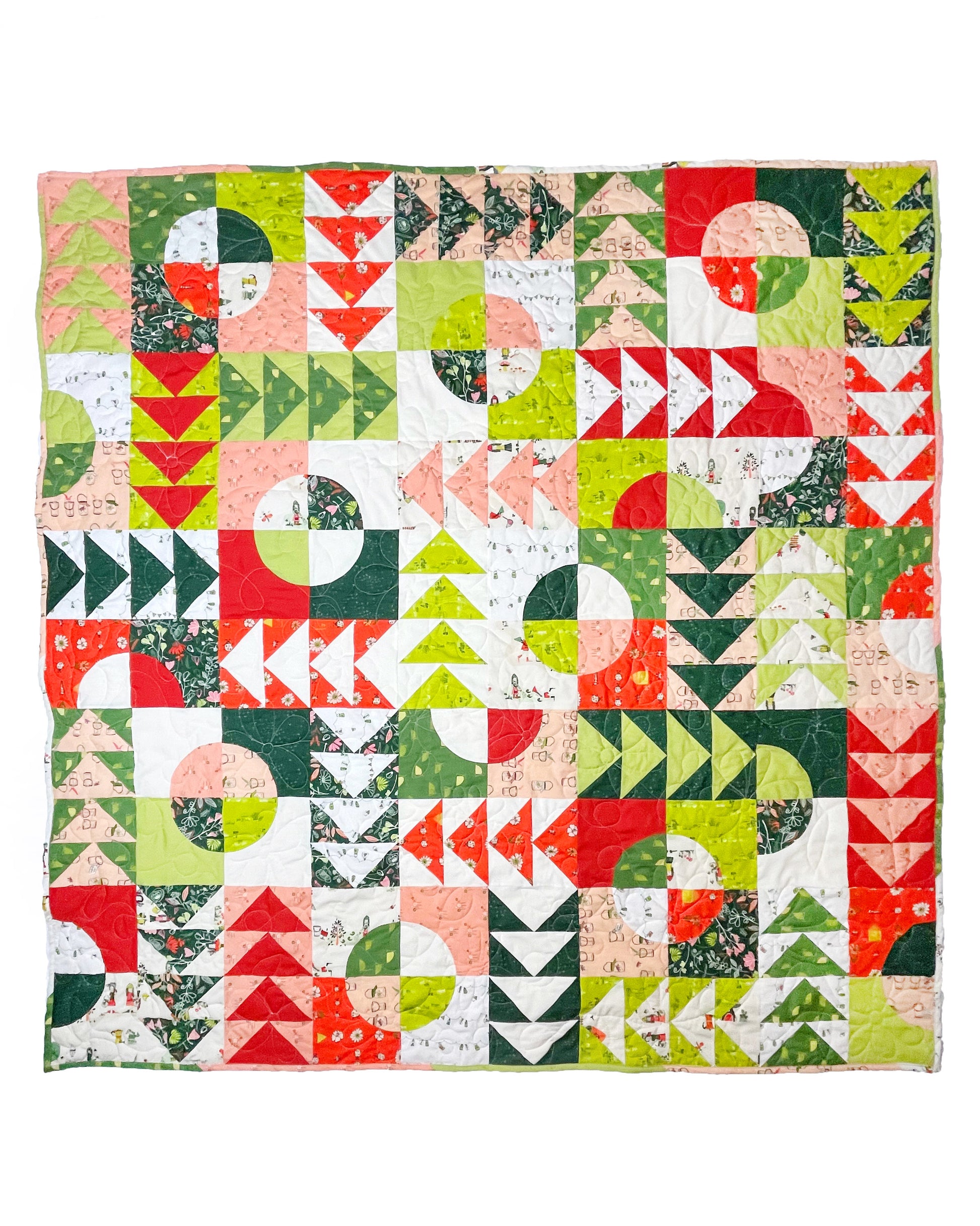 Carrol’s Garden quilt. A geometric quilt with quarter circles distributed with groups of four flying geese. Made of green, red, peach, and white fabrics. Displayed flat on a white surface.